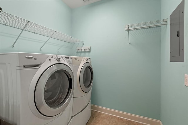 washroom featuring laundry area, electric panel, baseboards, and washing machine and clothes dryer