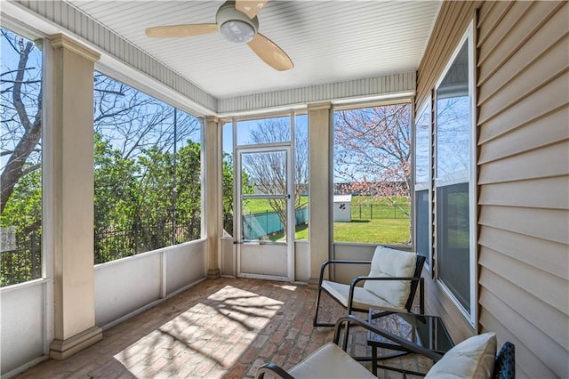 sunroom / solarium featuring a ceiling fan