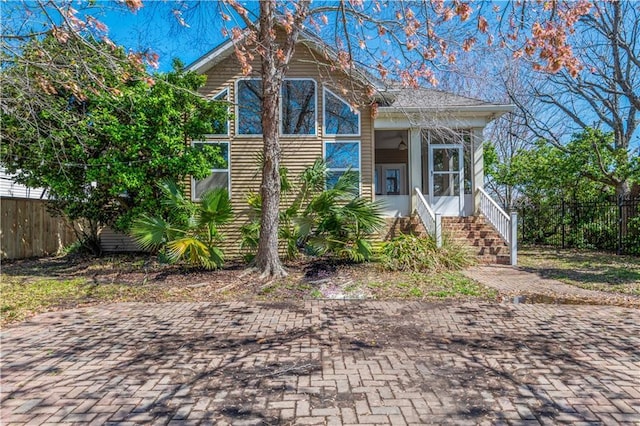 view of front of property featuring fence and a sunroom