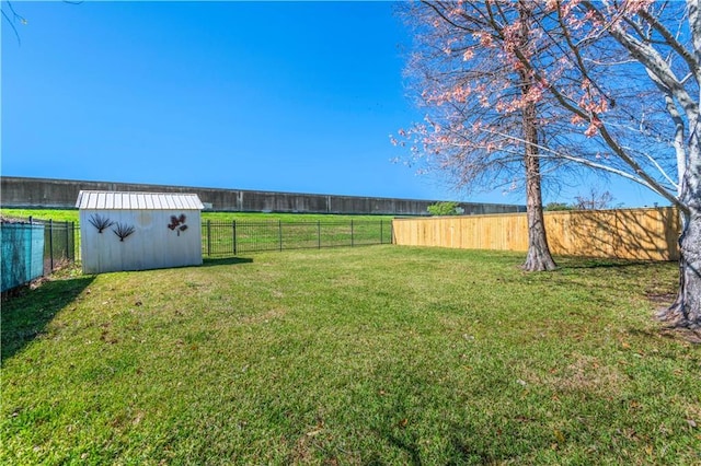 view of yard featuring an outbuilding, a shed, and a fenced backyard