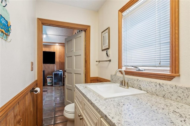 641 Petit Berdot Dr, Kenner, LA 70065 - half bathroom with vanity, toilet, a wainscoted wall, and tile patterned floors