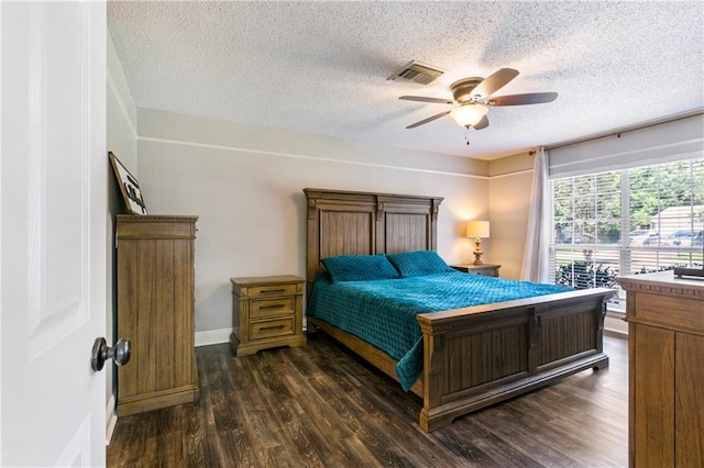 bedroom with dark wood-style floors, baseboards, visible vents, ceiling fan, and a textured ceiling