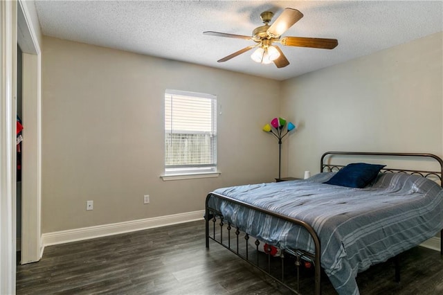 bedroom featuring ceiling fan, baseboards, a textured ceiling, and wood finished floors