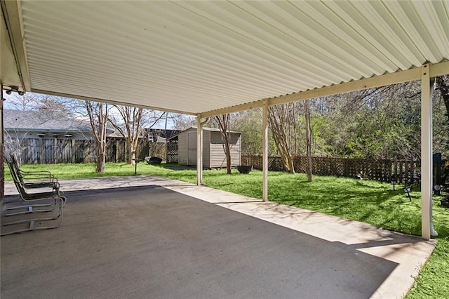 view of patio / terrace featuring a storage shed, a fenced backyard, and an outbuilding