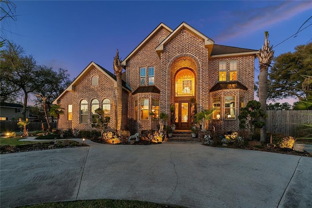 view of front of property with brick siding and fence