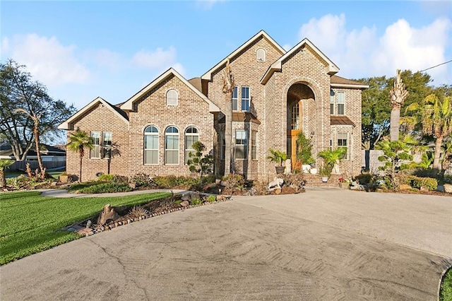 view of front of property featuring a front yard and brick siding