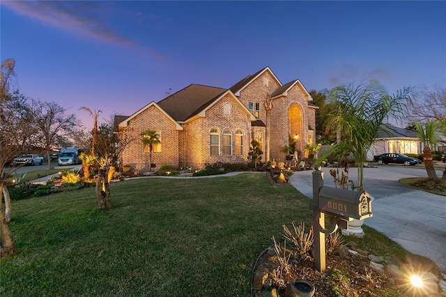 view of front facade featuring crawl space, a front lawn, concrete driveway, and brick siding