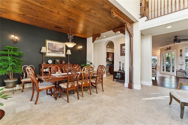 dining area with arched walkways, a ceiling fan, visible vents, wood ceiling, and baseboards