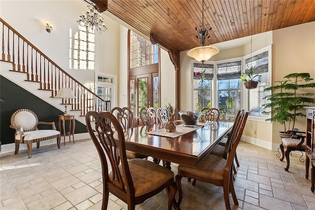 dining space featuring baseboards, stairway, wood ceiling, and stone tile floors