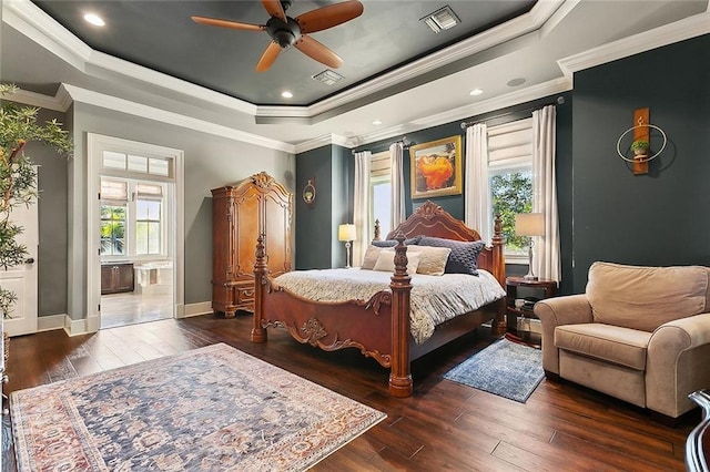 bedroom featuring visible vents, a tray ceiling, wood-type flooring, and baseboards