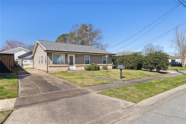 view of front of home with roof with shingles, a front lawn, and brick siding