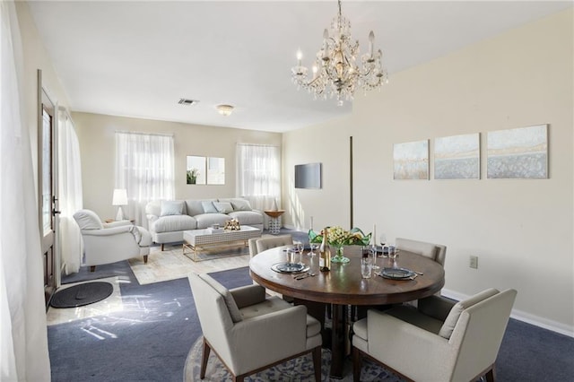 carpeted dining area with a chandelier, visible vents, and baseboards