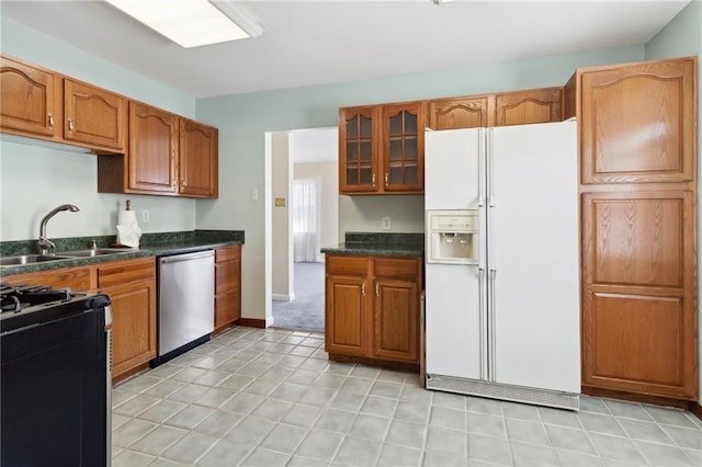 kitchen with glass insert cabinets, a sink, gas range, white fridge with ice dispenser, and dishwasher