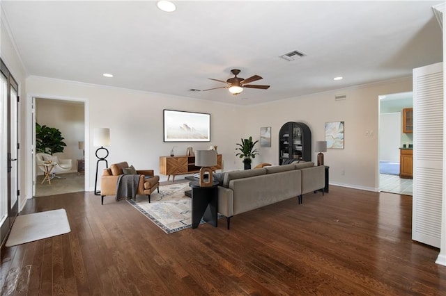 living area with dark wood-style floors, recessed lighting, visible vents, and crown molding