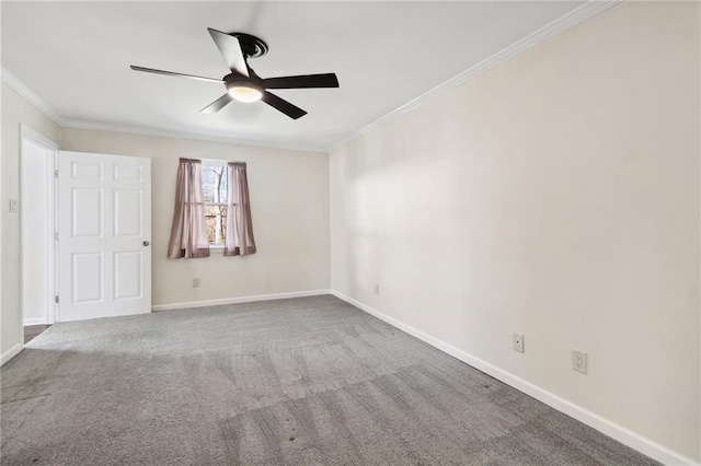 carpeted spare room featuring ceiling fan, baseboards, and crown molding