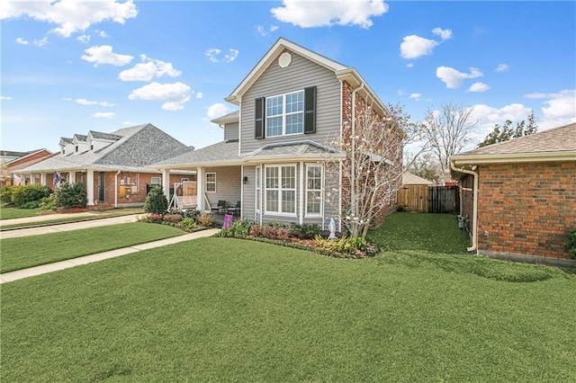 traditional home with a front yard and fence