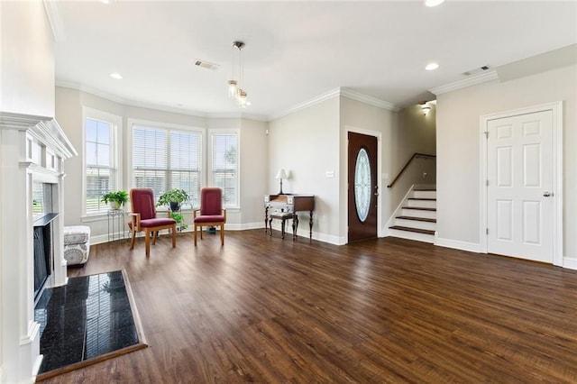 living area featuring baseboards, visible vents, a premium fireplace, wood finished floors, and stairs