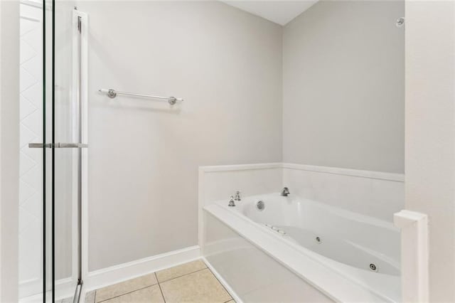 bathroom with a shower with door, a jetted tub, baseboards, and tile patterned floors