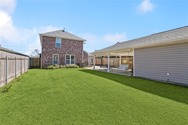 rear view of house featuring brick siding, a patio, a shingled roof, a lawn, and a fenced backyard