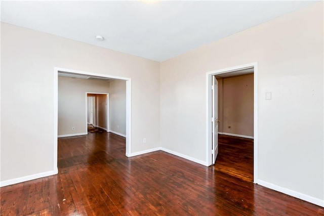 spare room with baseboards and hardwood / wood-style flooring