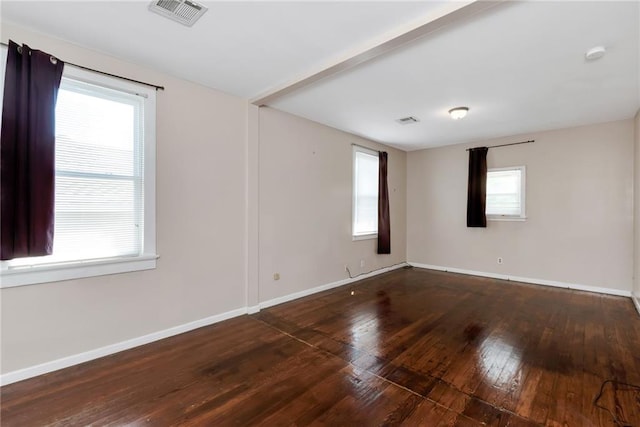 spare room featuring visible vents, baseboards, and hardwood / wood-style flooring