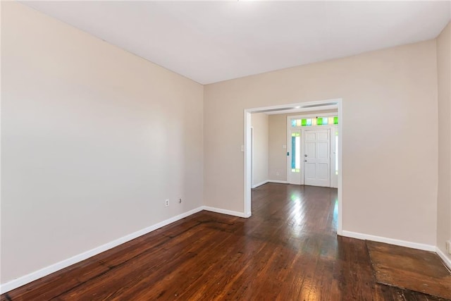 spare room with dark wood-style floors and baseboards