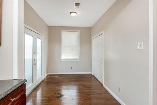 foyer entrance with dark wood-type flooring, french doors, visible vents, and baseboards