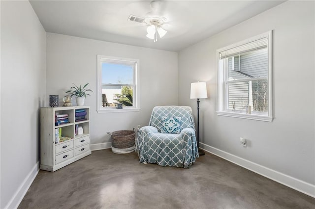 living area featuring a ceiling fan, visible vents, and baseboards