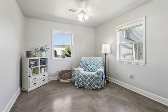 sitting room featuring visible vents, a ceiling fan, baseboards, and a wealth of natural light
