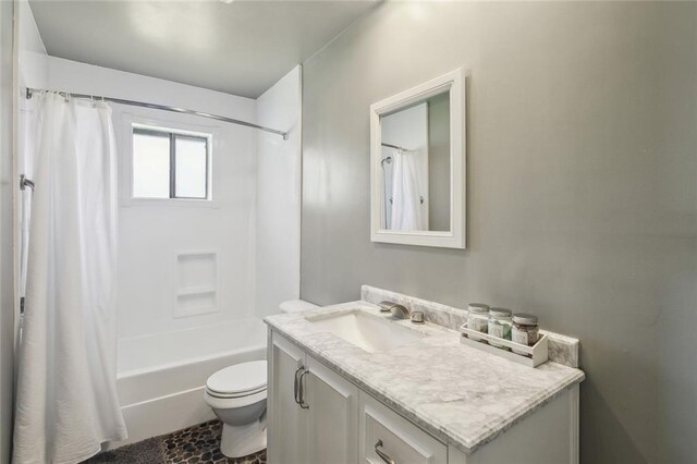 bathroom with vanity, shower / bath combo with shower curtain, and toilet