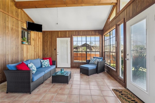 sunroom featuring wood walls, lofted ceiling with beams, and tile patterned floors