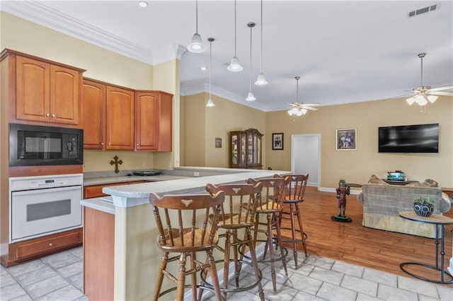 kitchen featuring black microwave, visible vents, a ceiling fan, and white oven