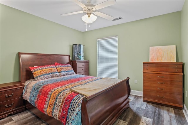 bedroom with ceiling fan, wood finished floors, visible vents, and baseboards