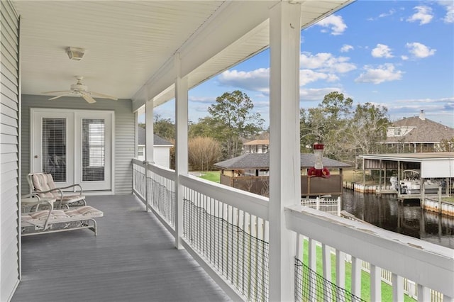 balcony with a water view and a ceiling fan