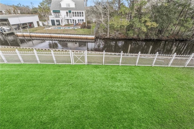 view of yard with a fenced backyard and a water view