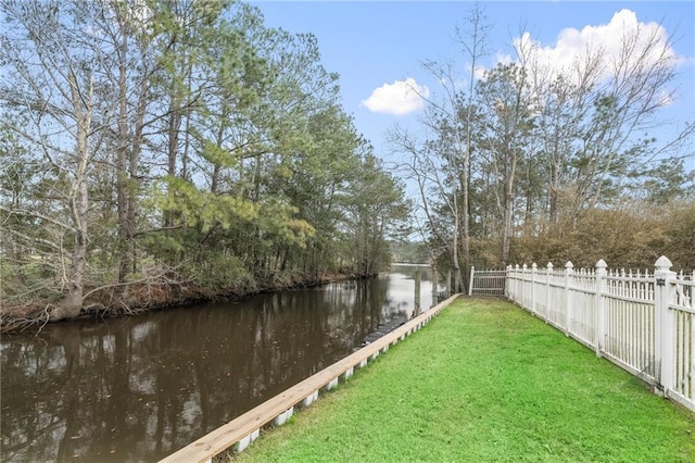 view of yard with a water view and fence