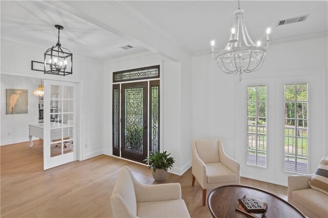 sitting room with french doors, visible vents, crown molding, and an inviting chandelier