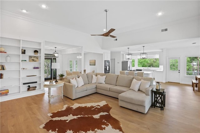 living room with light wood-style floors, recessed lighting, visible vents, and an inviting chandelier