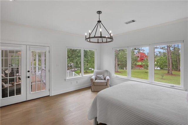 bedroom featuring light wood finished floors, visible vents, baseboards, access to outside, and crown molding