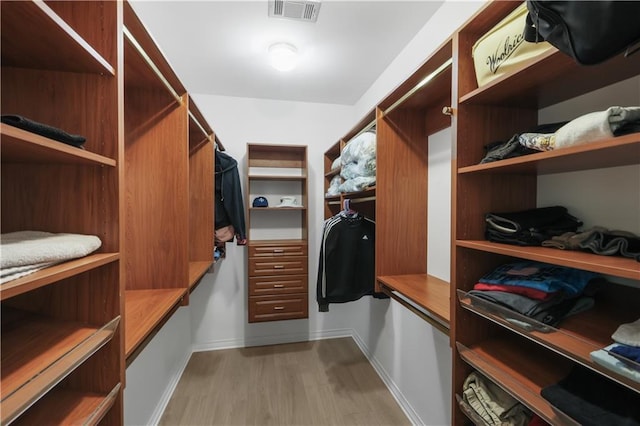 walk in closet with light wood-type flooring and visible vents