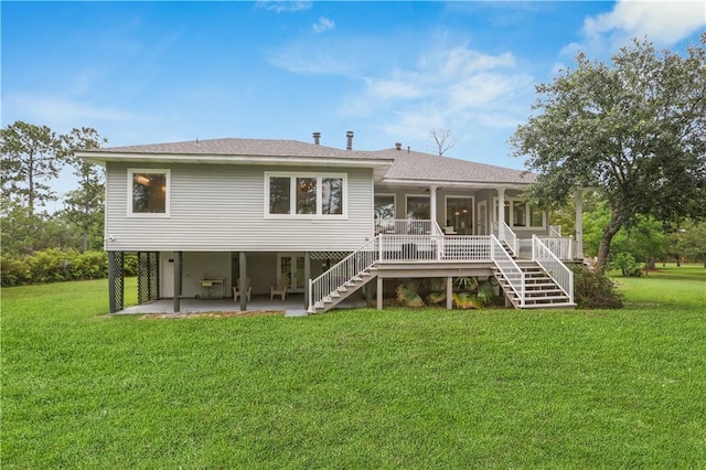 rear view of property with roof with shingles, a patio, a lawn, stairway, and a carport