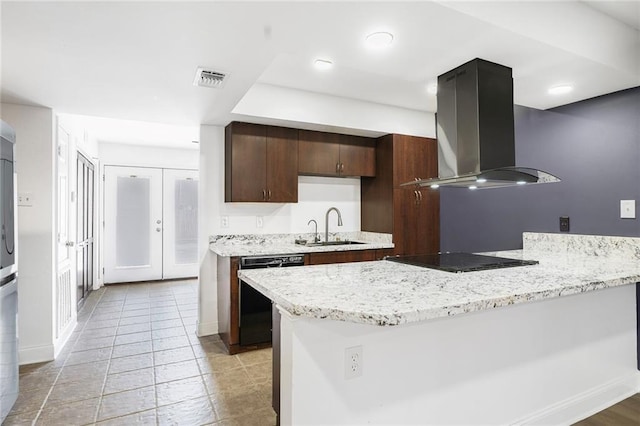 kitchen featuring visible vents, black appliances, a sink, a peninsula, and island range hood