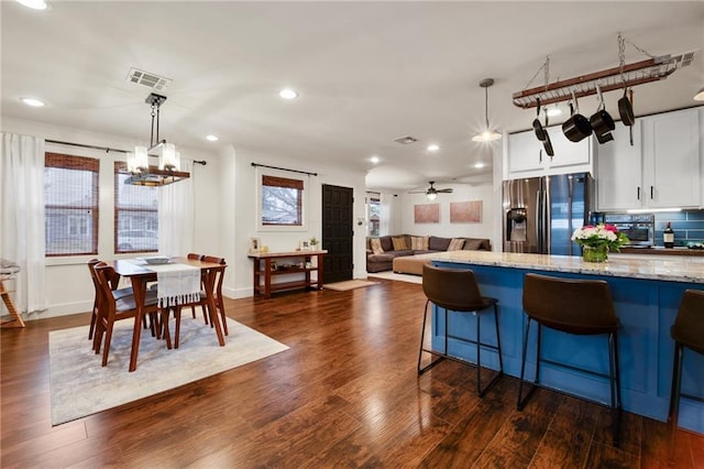 kitchen with decorative backsplash, dark wood finished floors, light stone counters, white cabinetry, and stainless steel refrigerator with ice dispenser