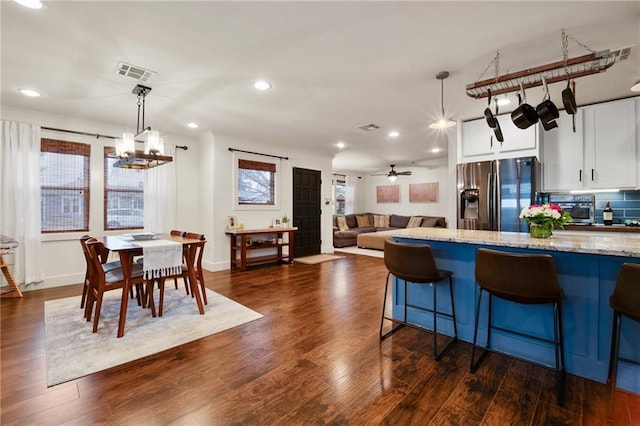 132 Coventry Ct, River Ridge, LA 70123 - kitchen with dark wood-style flooring, light stone counters, stainless steel fridge, white cabinets, and decorative backsplash