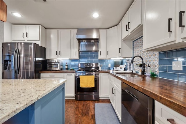 kitchen featuring decorative backsplash, dark wood-style floors, butcher block counters, appliances with stainless steel finishes, and a sink