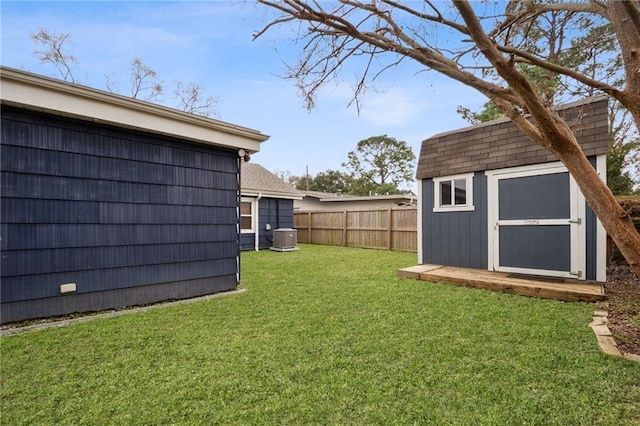 view of yard featuring a storage unit, an outdoor structure, a fenced backyard, and central air condition unit