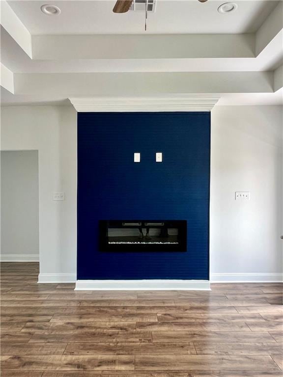 room details featuring a fireplace, baseboards, and wood finished floors