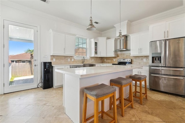 kitchen with a breakfast bar, stainless steel refrigerator with ice dispenser, tasteful backsplash, electric range, and wall chimney exhaust hood