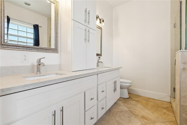 full bath featuring double vanity, a sink, toilet, and tile patterned floors