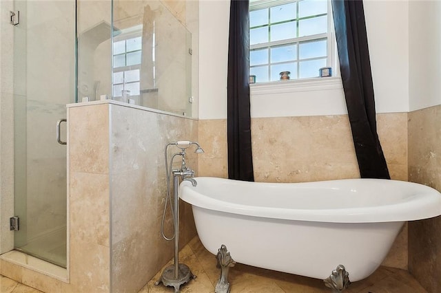 bathroom featuring a freestanding tub, a shower stall, tile walls, and a wainscoted wall